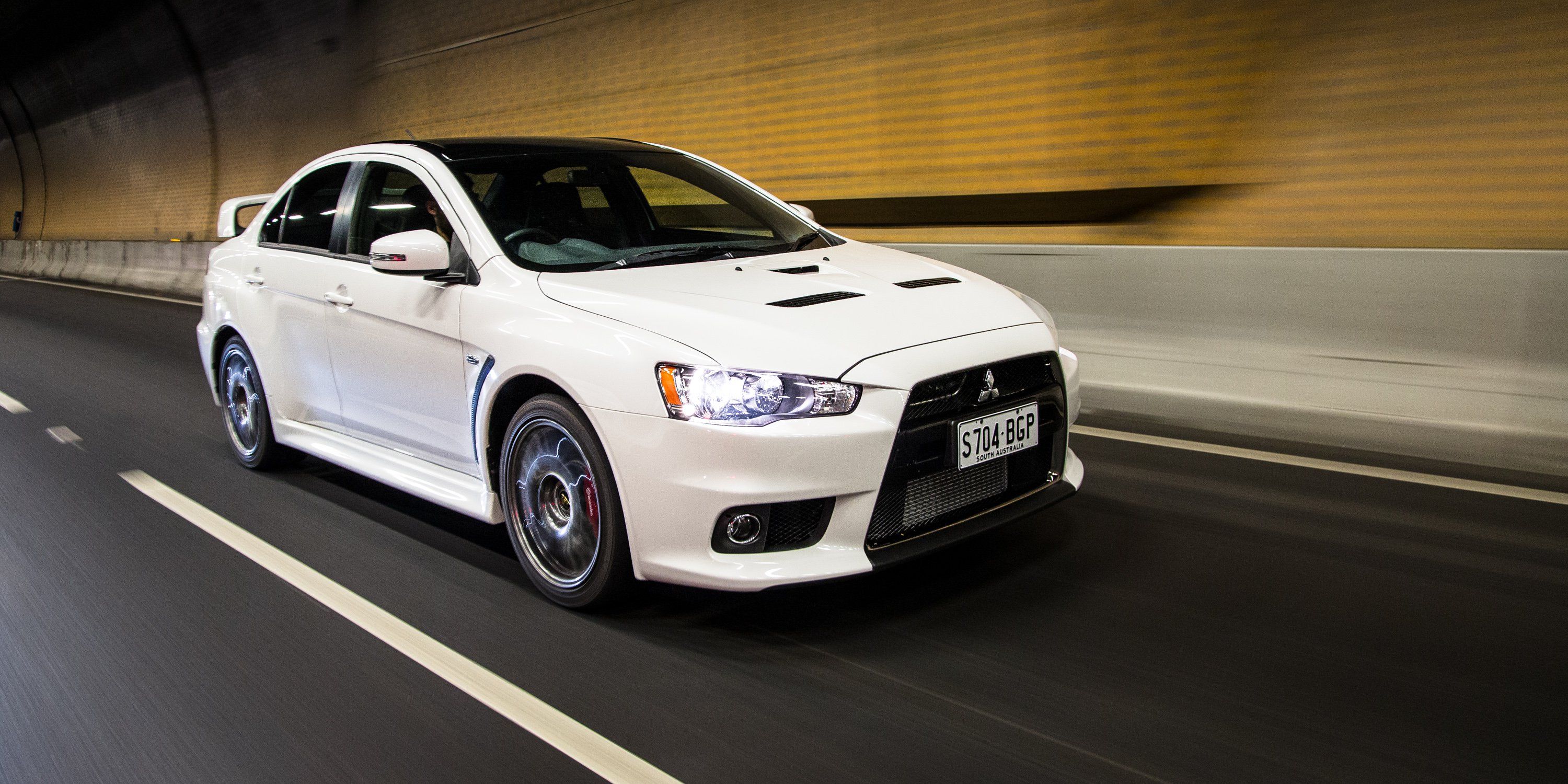 2014 Mitsubishi Lancer Evolution X in white, driving through a tunnel