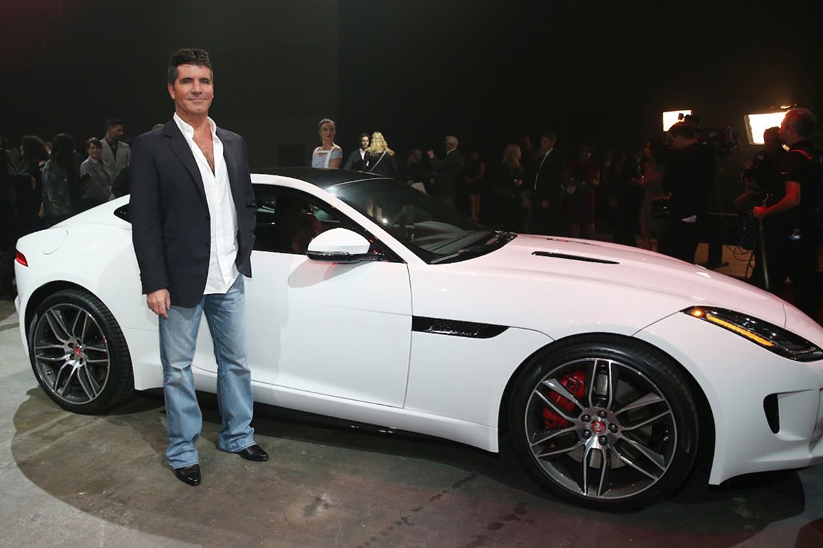 Simon Cowell standing in front of his white Jaguar F-Type