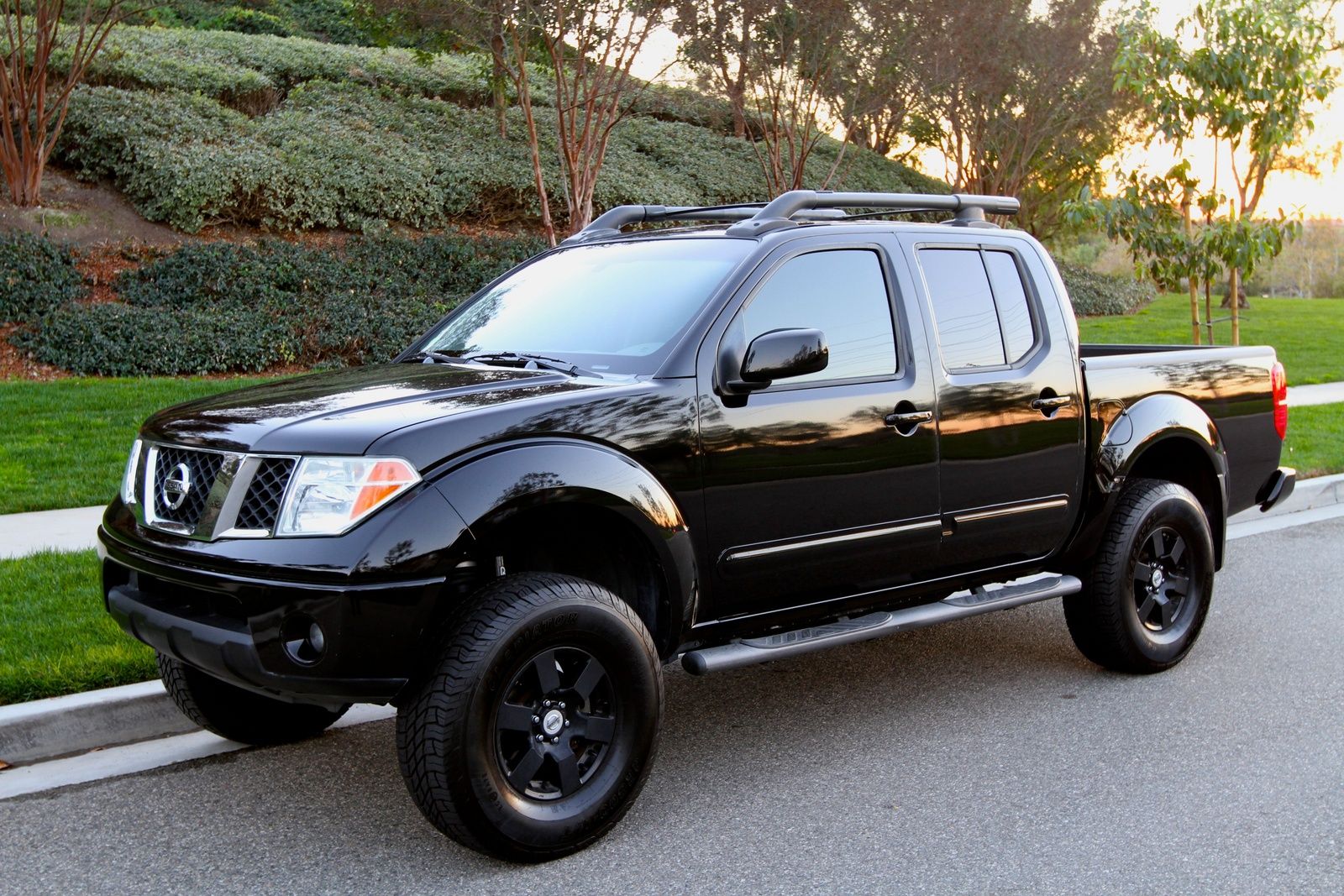 Black 2005 Nissan Frontier driving on the road