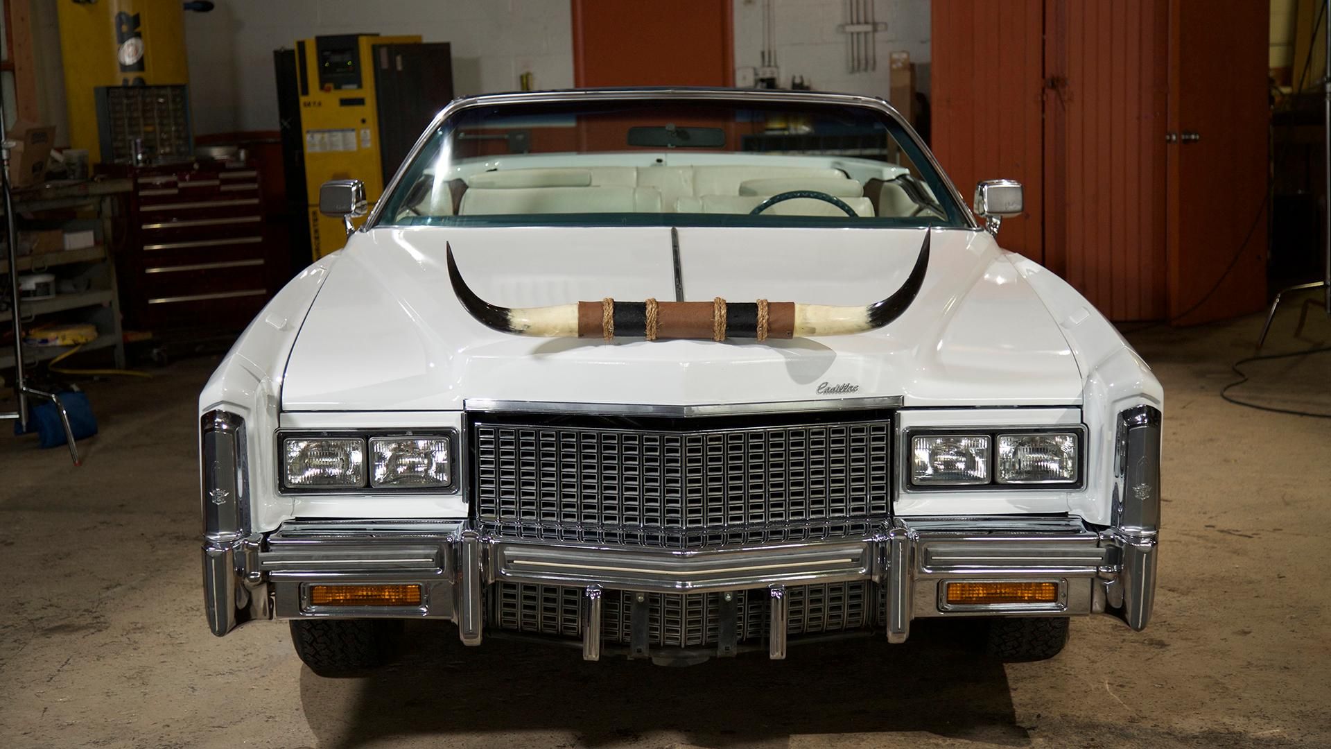 A Cadillac parked at the Junkyard Empire's workshop
