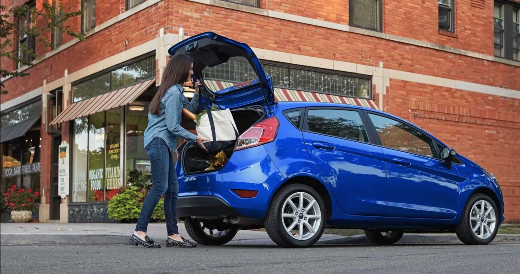 Woman packing the trunk of a Ford Fiesta hatchback