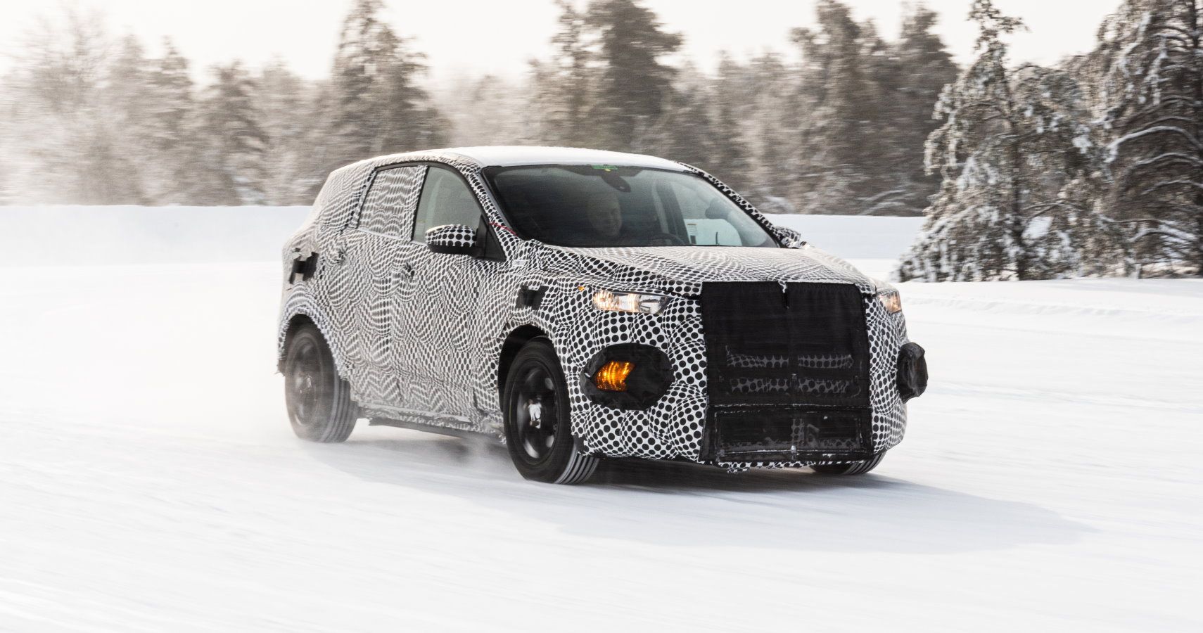 A prototype Ford electric vehicle testing in frigid, snowy conditions.