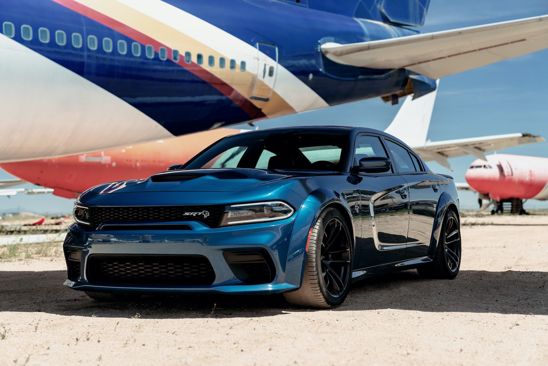 Blue 2020 Dodge Charger SRT Hellcat Widebody Parked Next to Airplane
