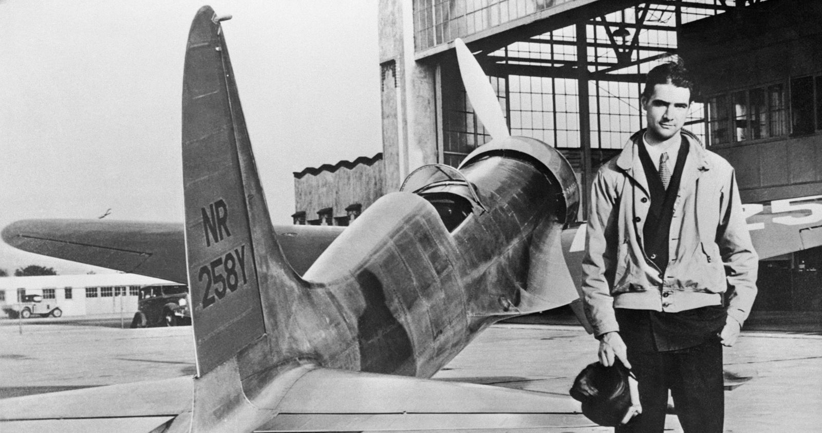 Howard Hughes standing front of his plane