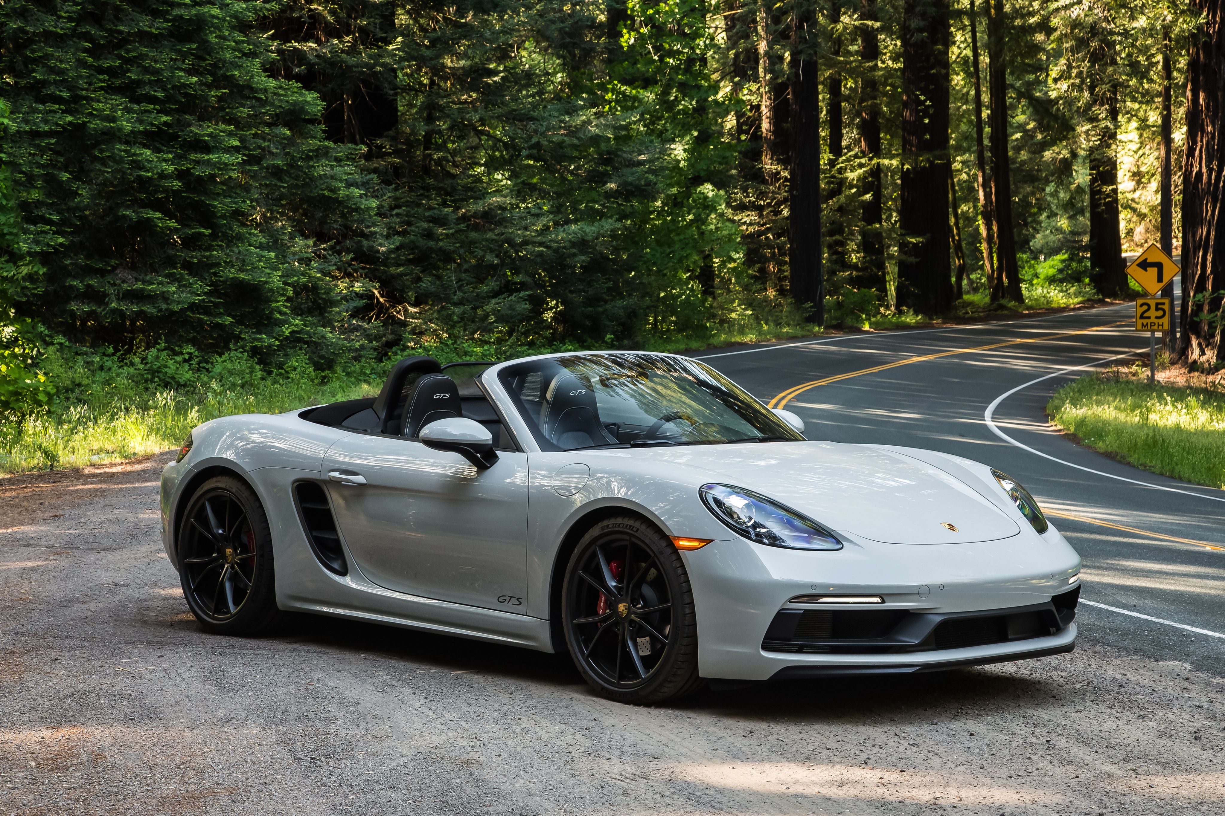 Light grey 2019 Porsche 718 Boxster convertible on a forest road