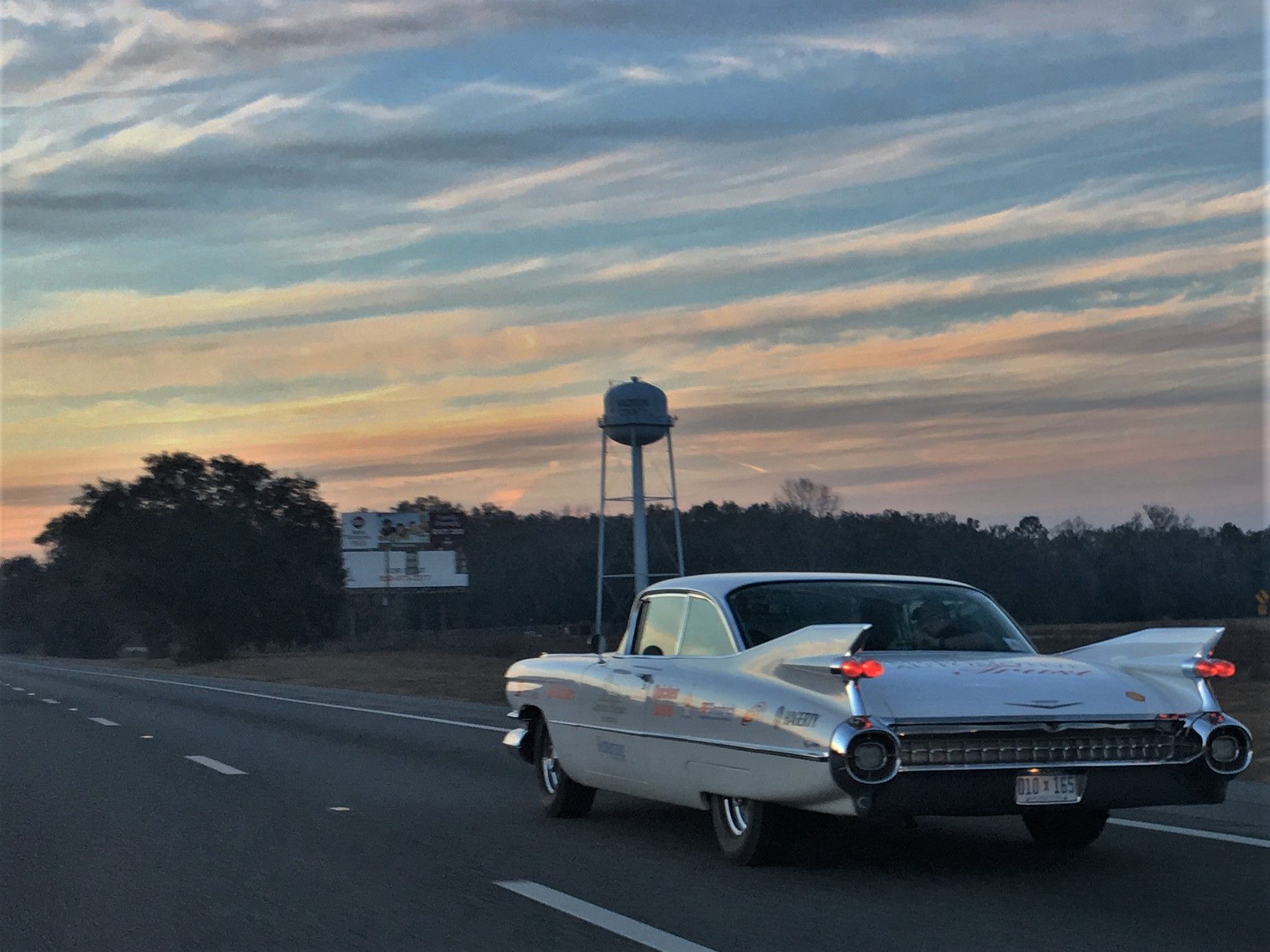 Classic car driving on roadway