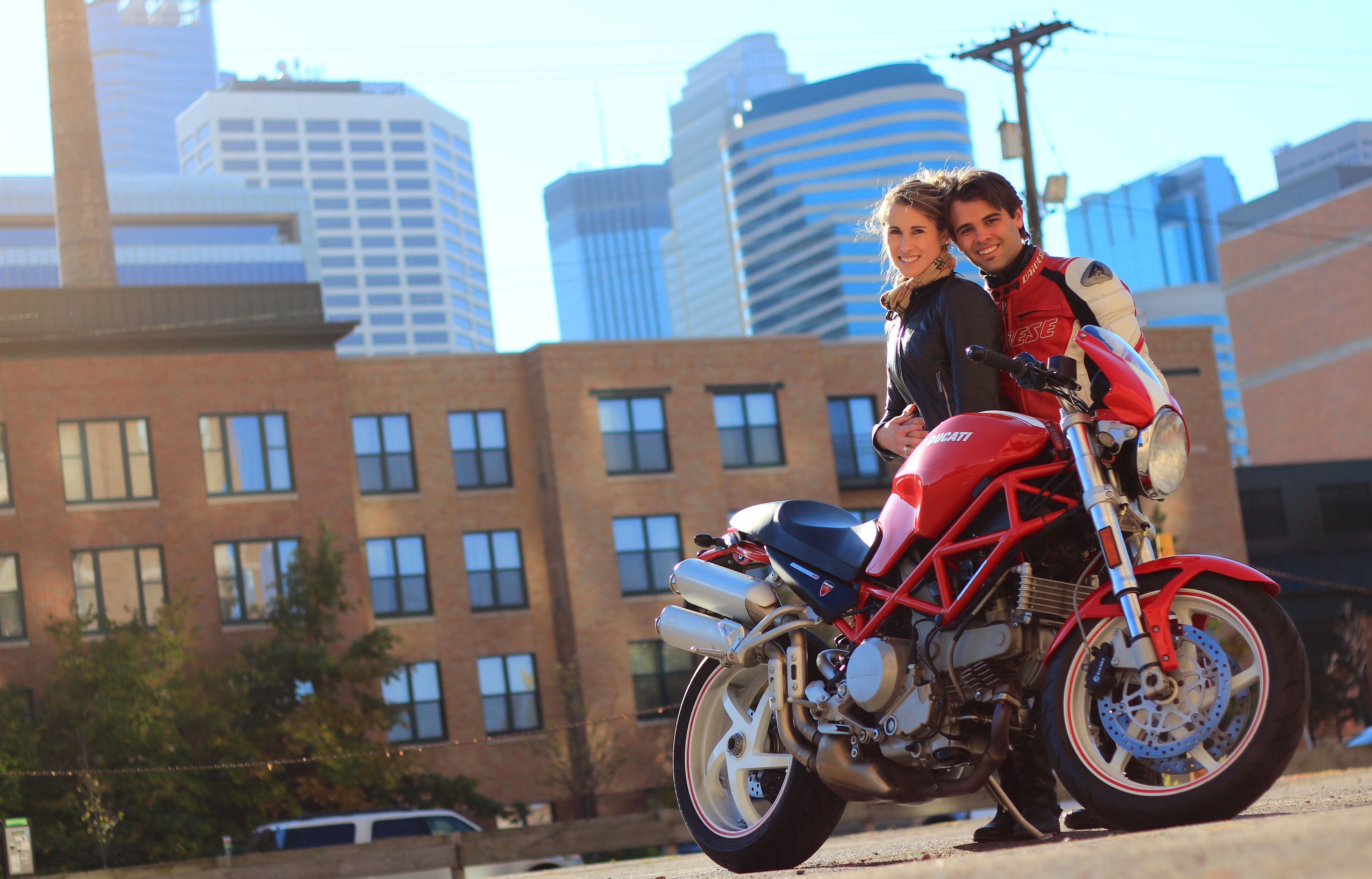 Couple posing behind a red Ducati motrocycle