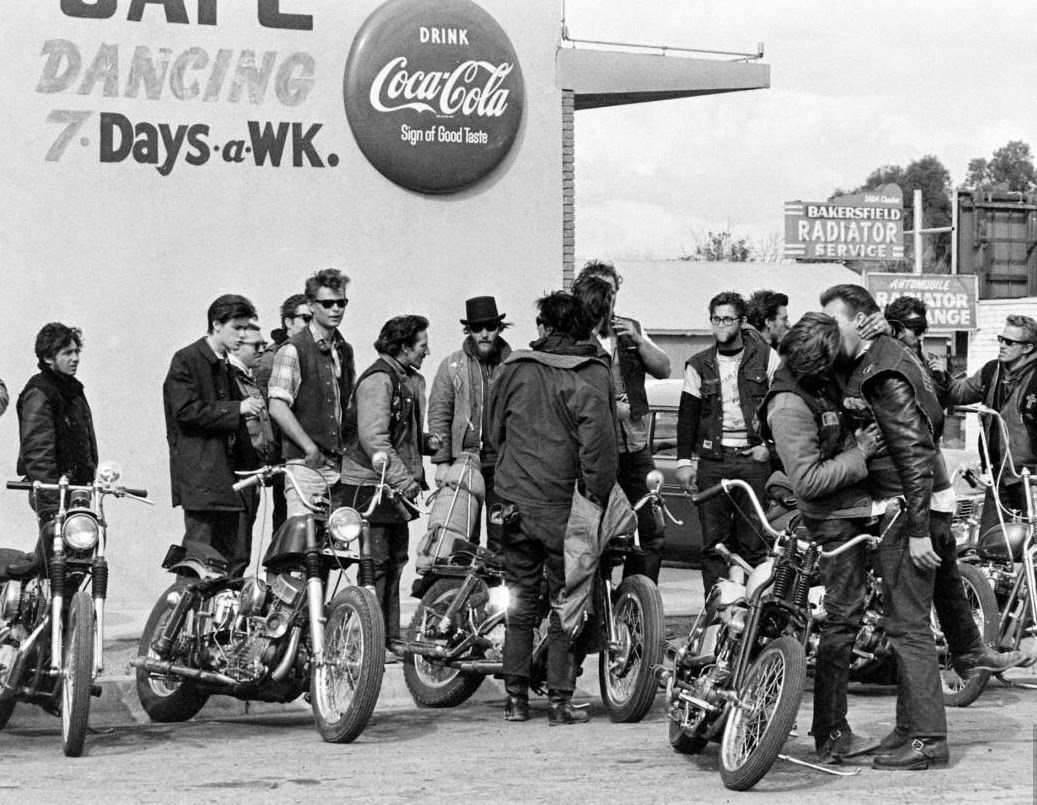 A group of Angels gather outside the well-known Blackboard Cafe in California, while two riders kiss.