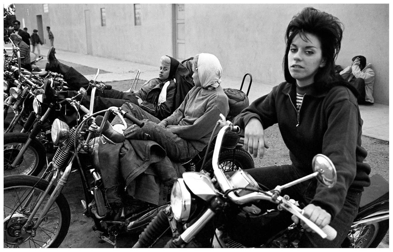 Ladies of the Hell's Angels lean up on beau's bikes as they make a stop along their travels in California.