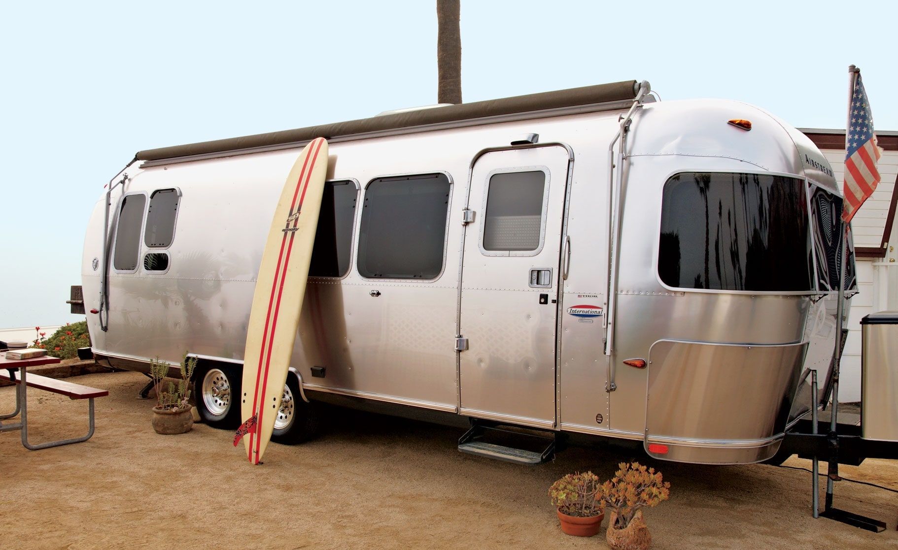 airstream trailer with a surfing board leaning against it