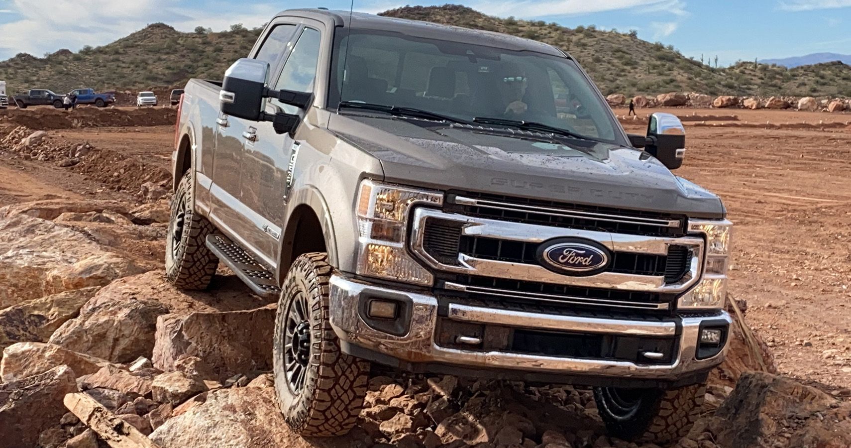 A Ford pickup truck drives in the dirt
