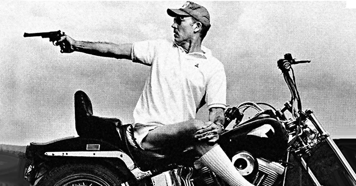 Hunter S. Thompson points gun while on Harley