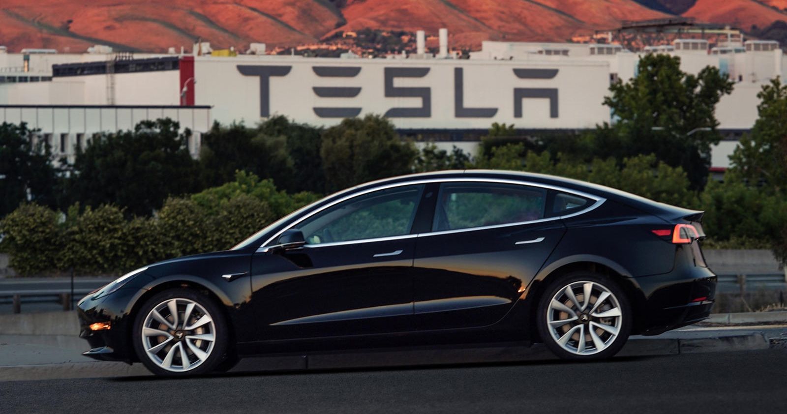 Tesla black in front of factory