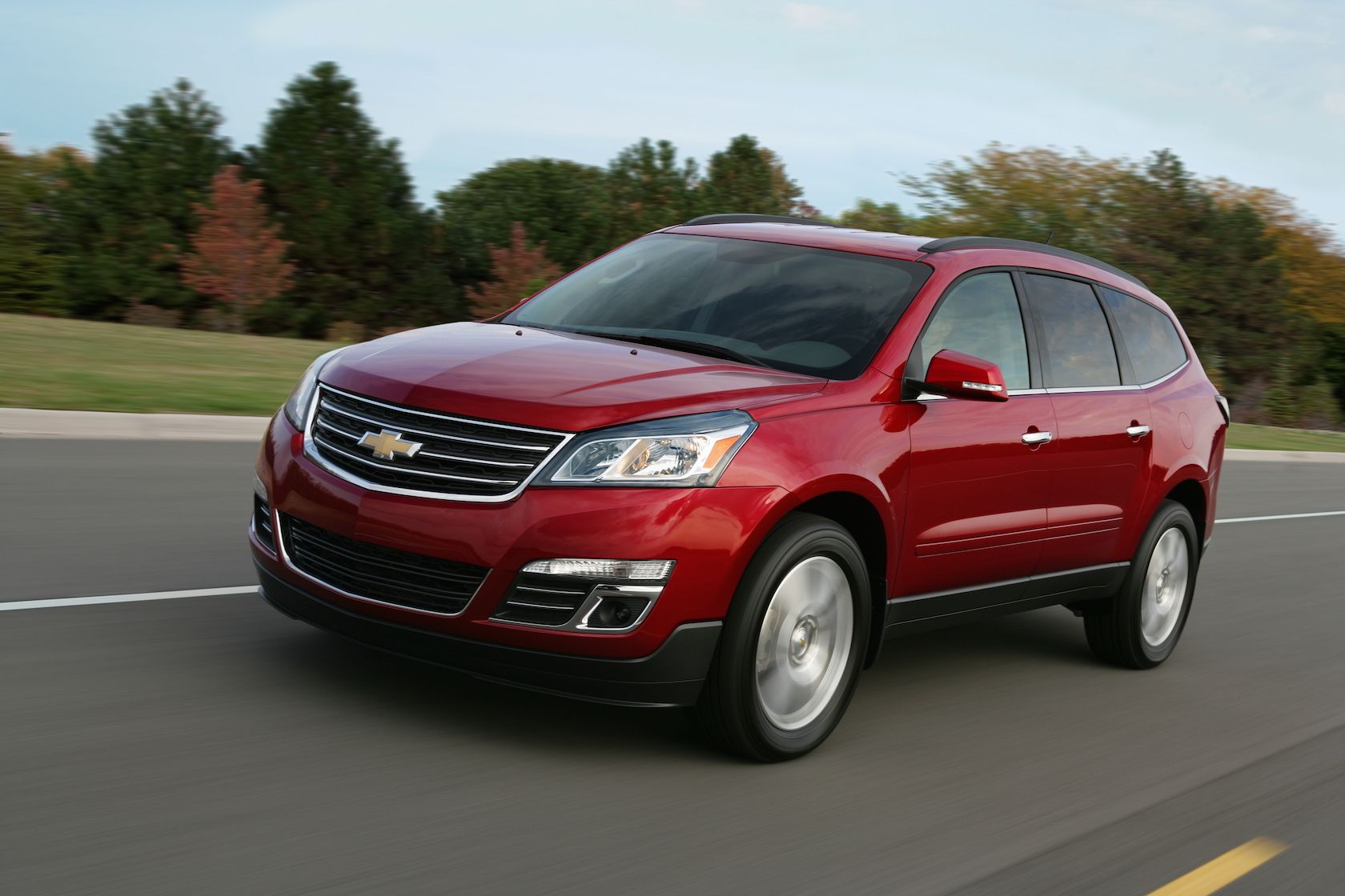 2015 Chevrolet Traverse in motion on road driving past greenery