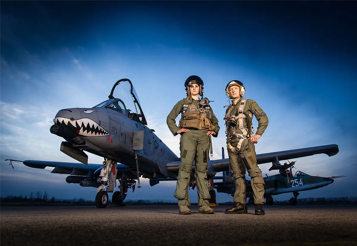 Two pilots stand in front of the famous Warthog