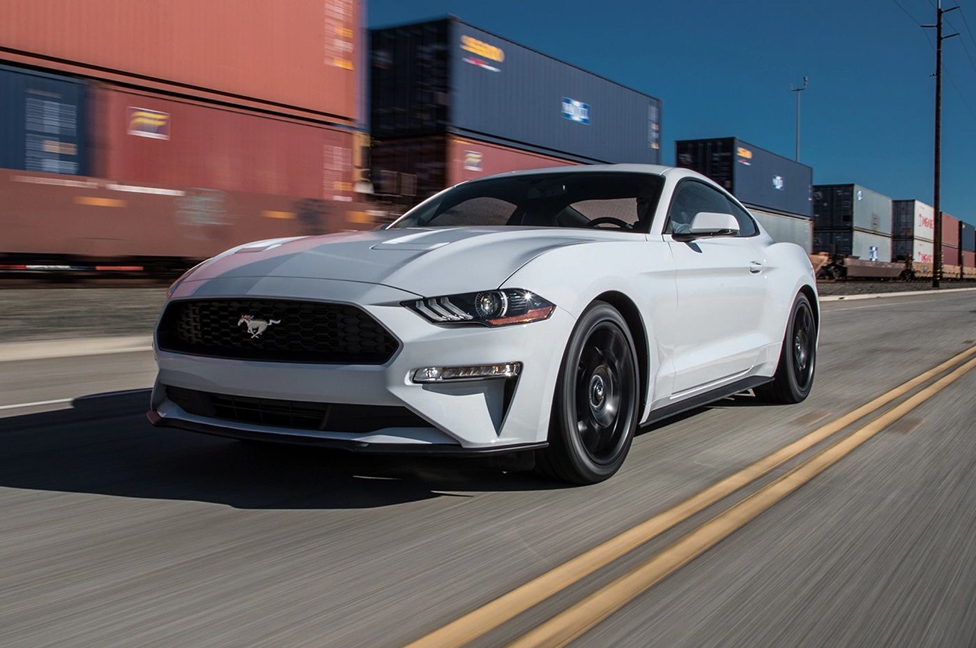 Oxford White 2018 Ford Mustang speeding on an urban road