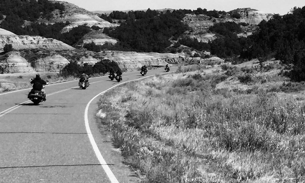 Hombres de la bici que van por la carretera