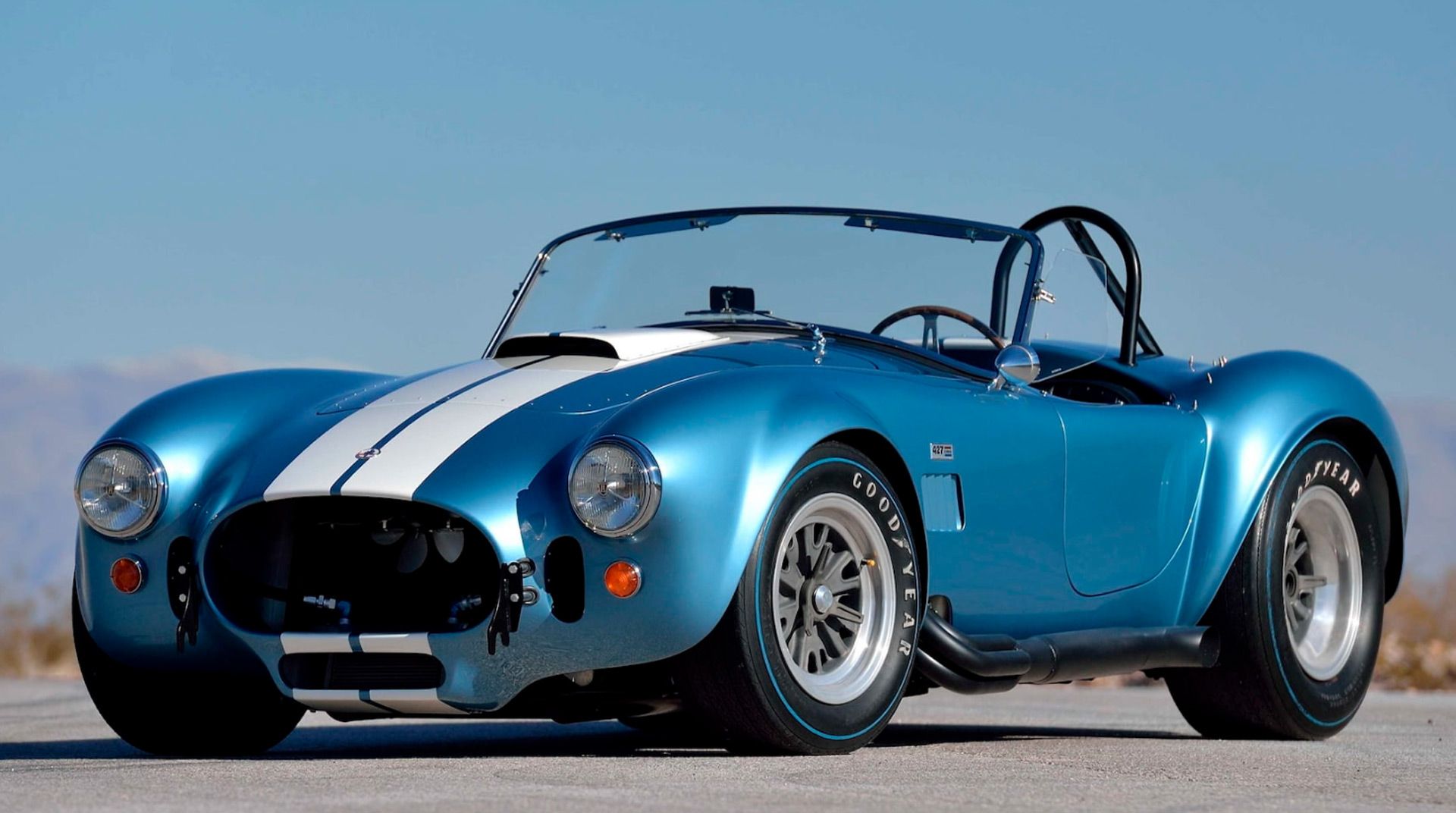 Bright Blue Shelby Cobra with white stripes showing off its charm under sunlight