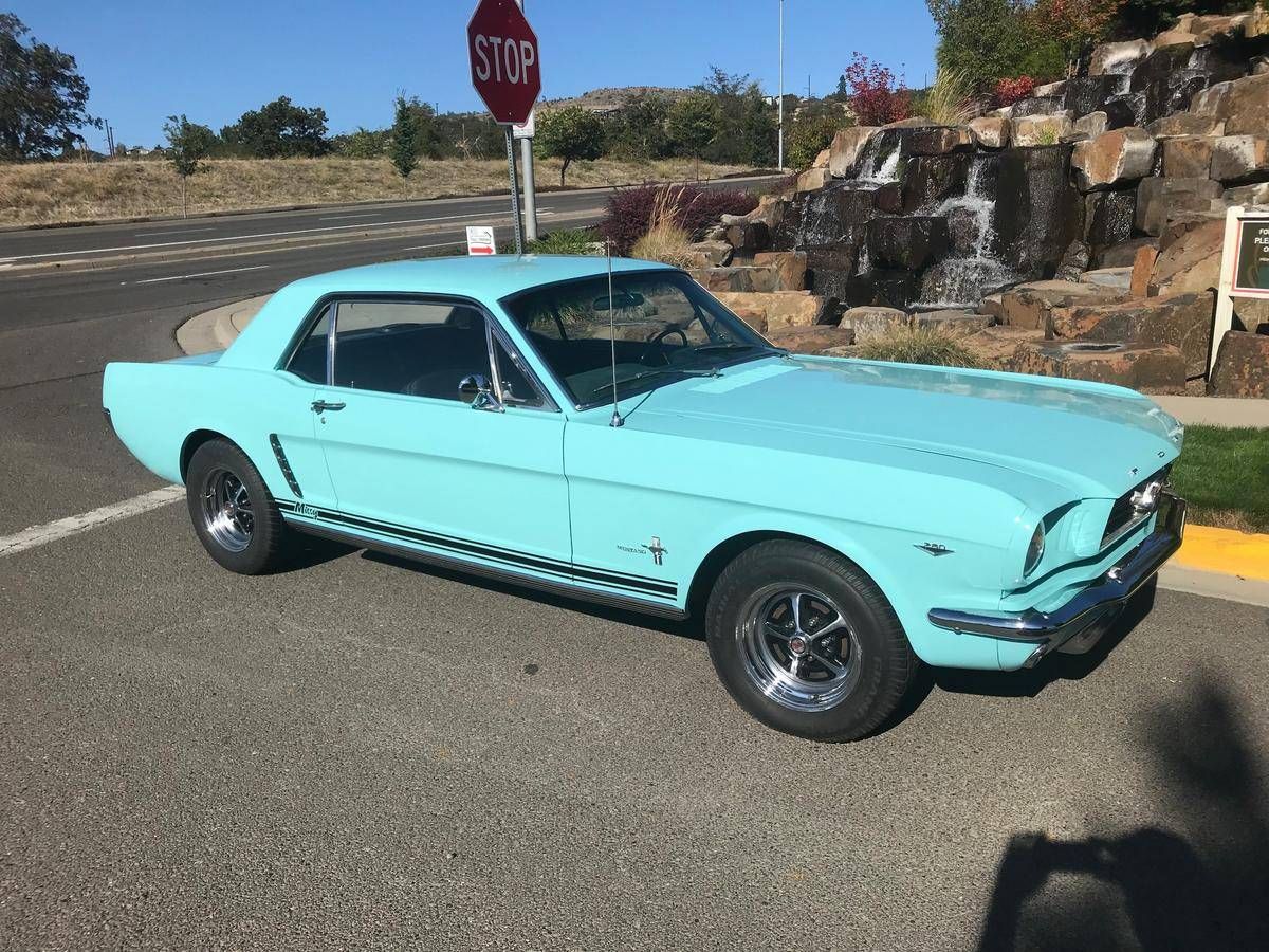 bluish-green Mustang in parking lot