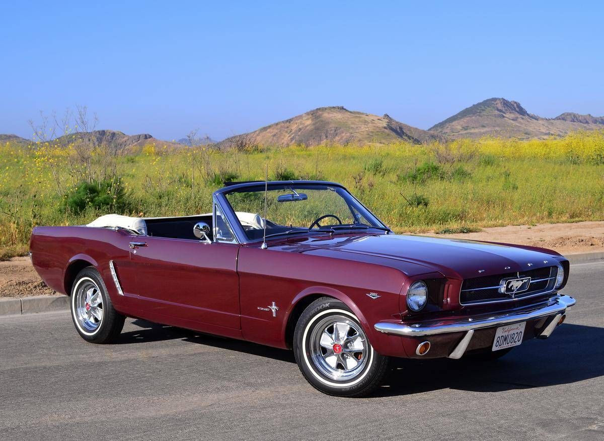 dark red Mustang convertible on road