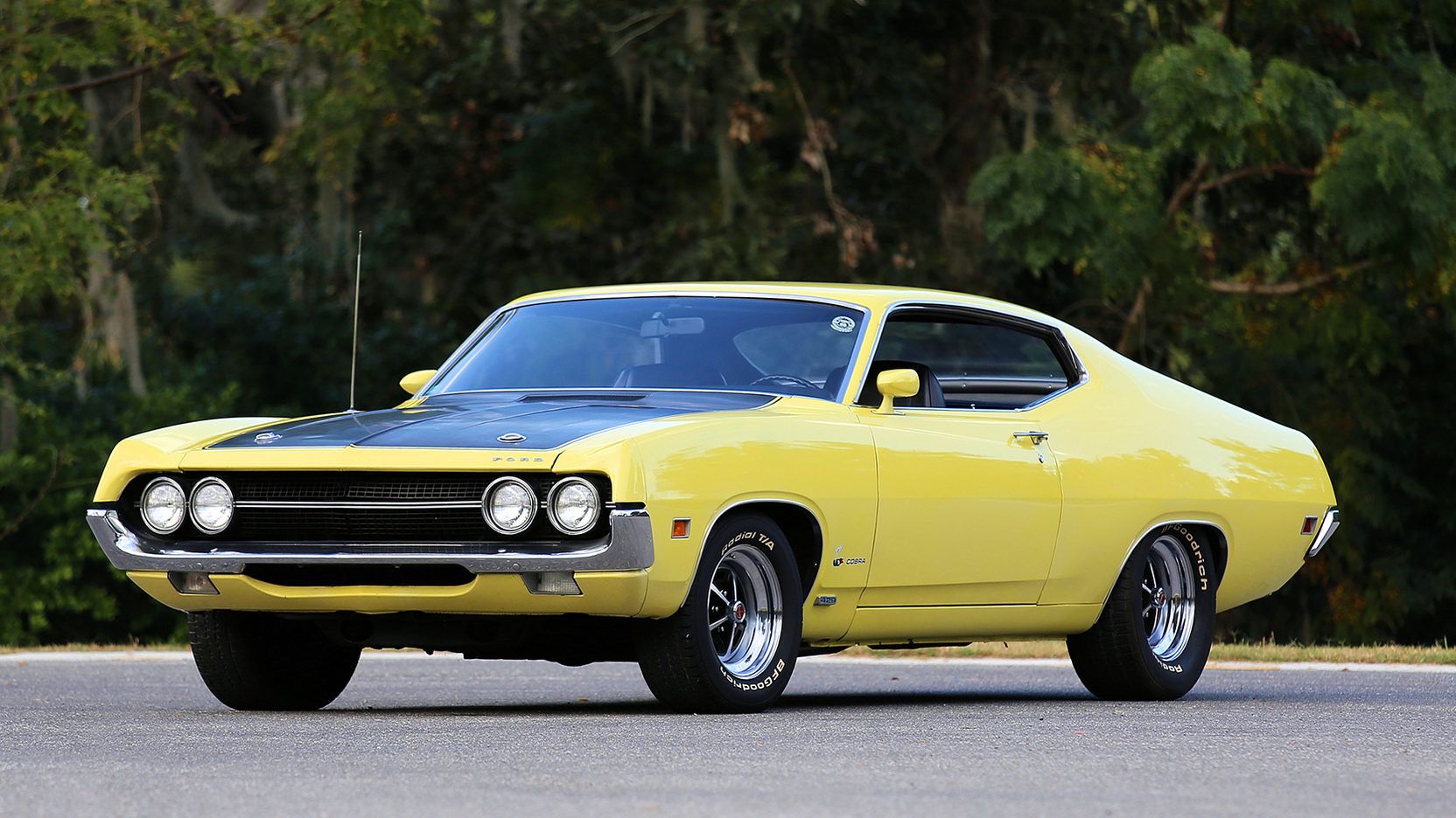 A yellow 1970 Ford Torino Cobra on the road