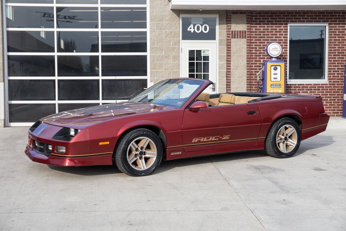 Copper Red 1987 Chevrolet Camaro IROC-Z Convertible in front of a shop