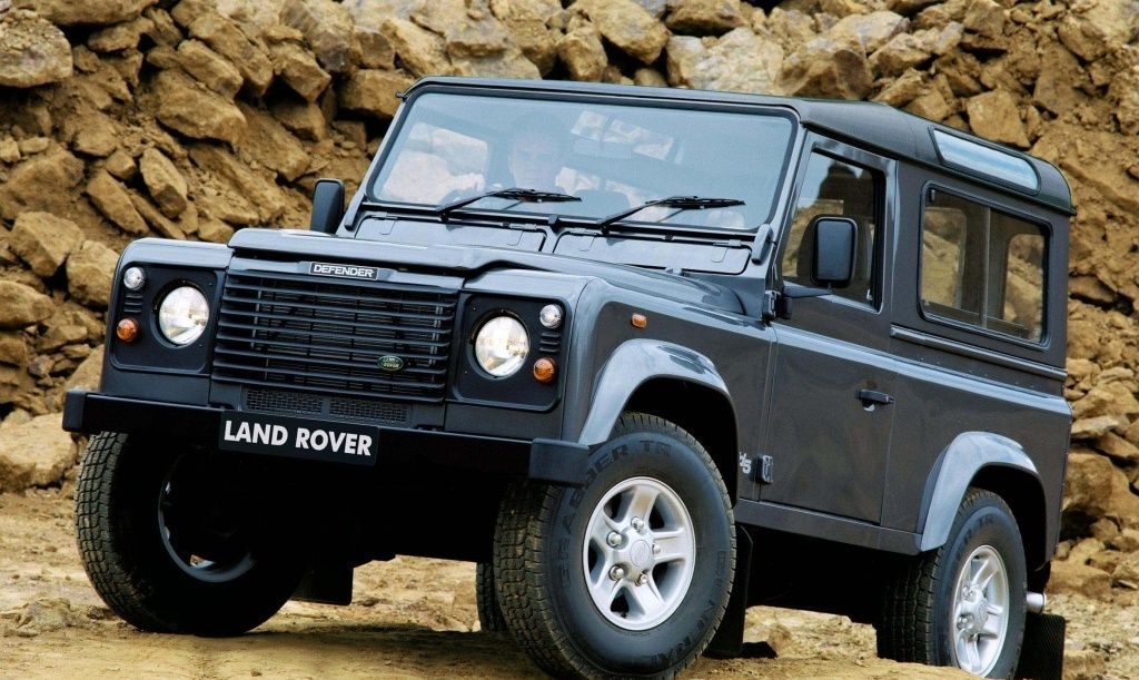 Gray 1991 Land Rover Defender driving over the rocks