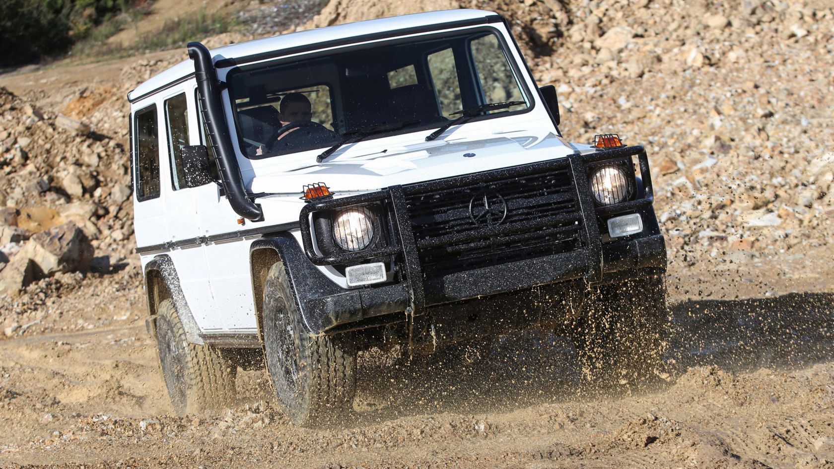 Polar White 1993 Mercedes-Benz G-Class W461 driving over the mud 
