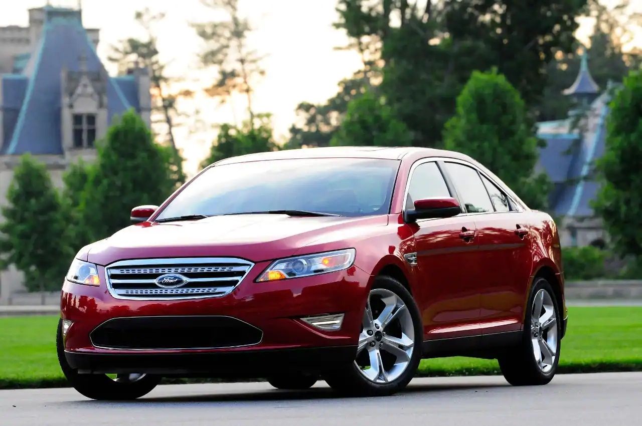 Candy Red Metallic Tinted Clearcoat 2010 Ford Taurus SHO parked on the side of a residential road