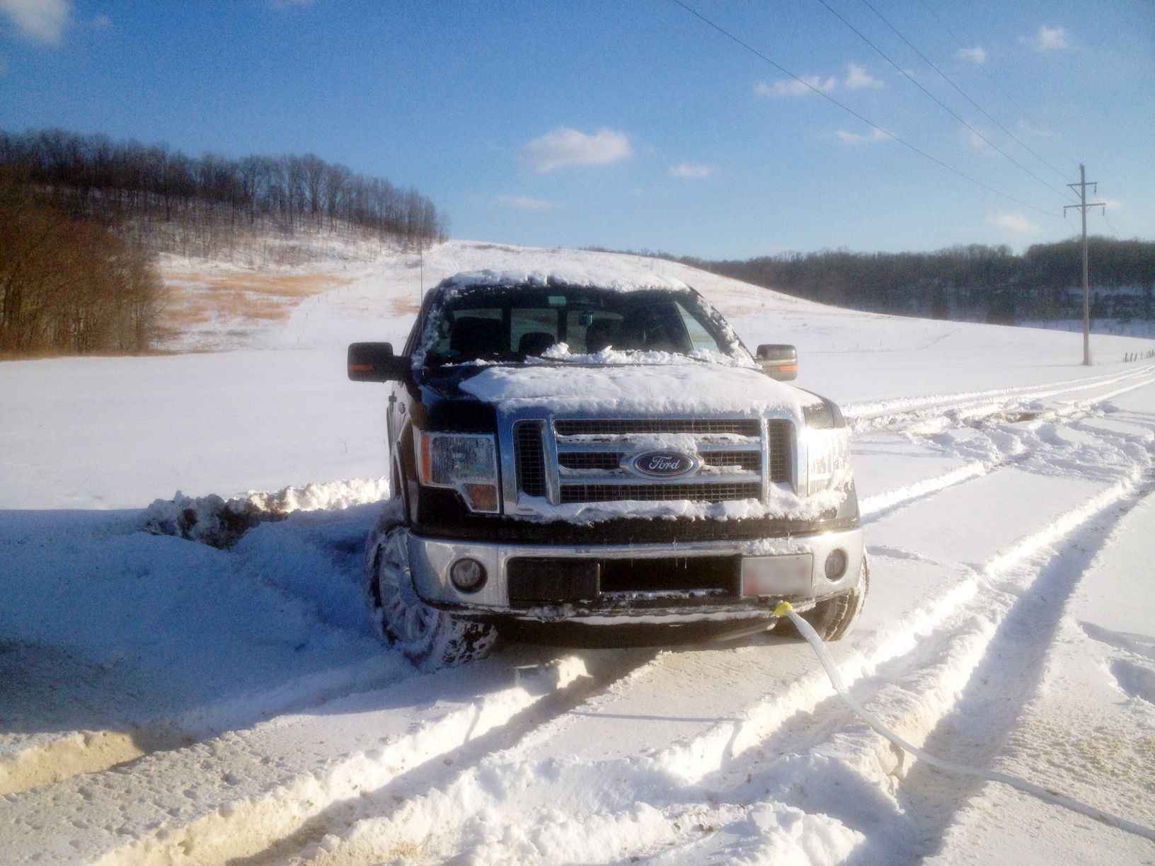 Black Ford F-150 stuck in heavy snowy 