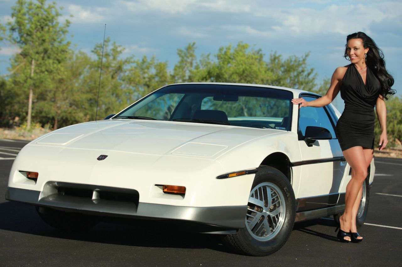 White hard top Pontiac Fiero shown by model