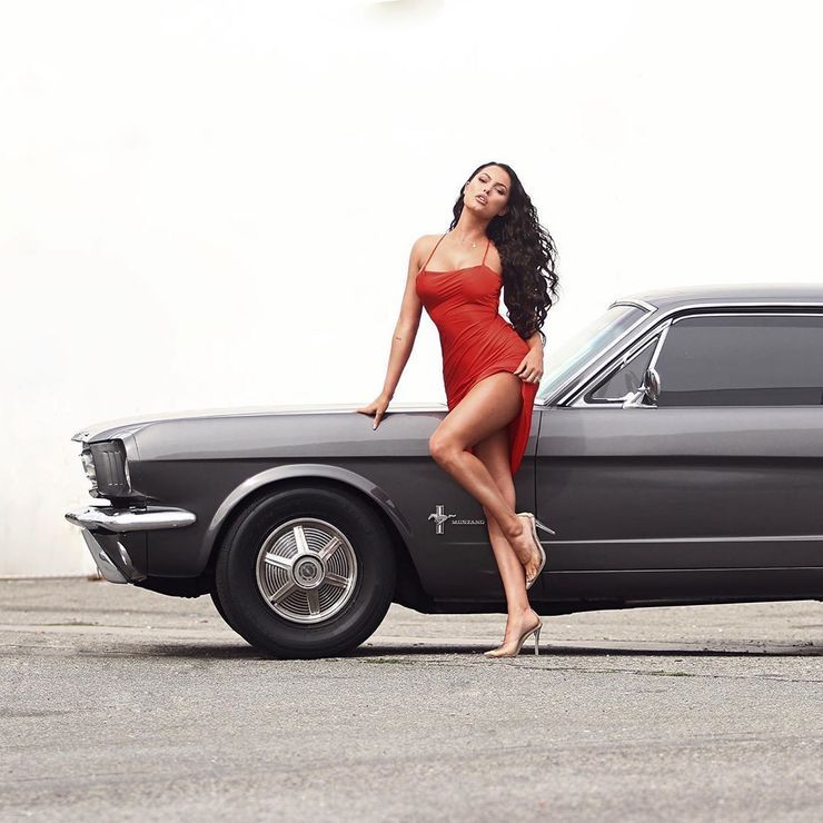 Constance Nunes posing in a red dress in front of Babystang