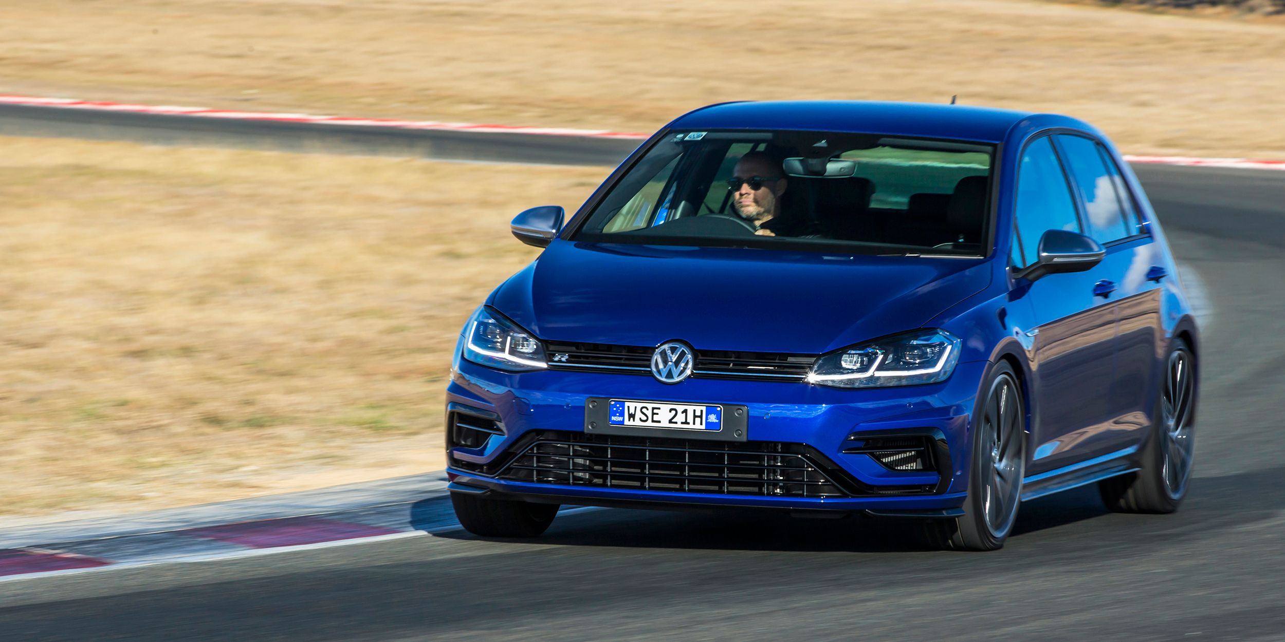 A blue volkswagen golf r on the highway