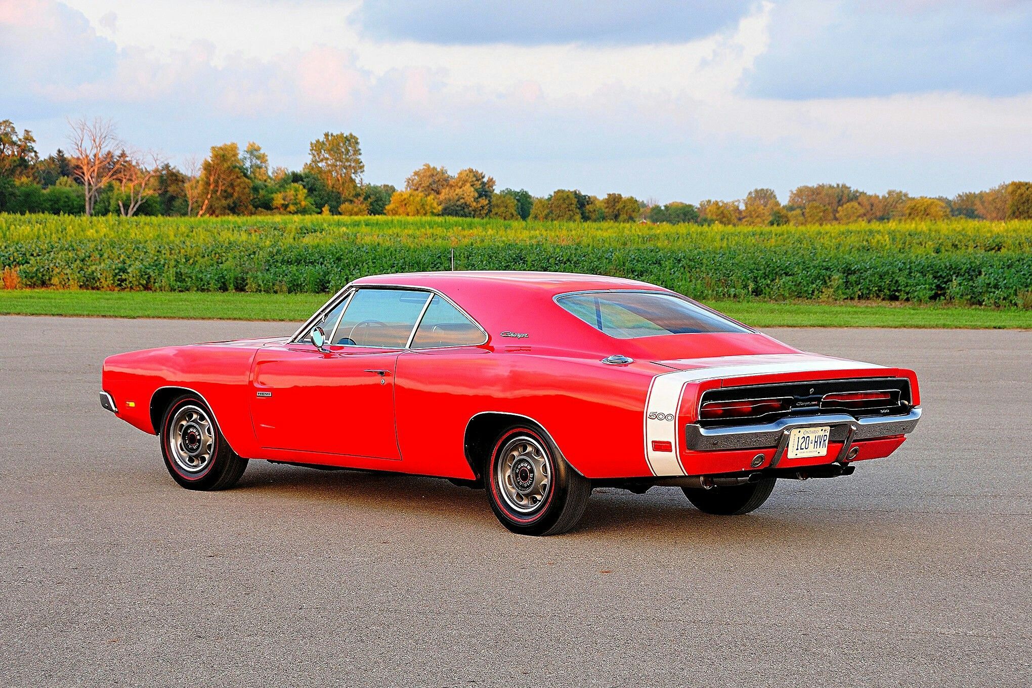 3/4 rear view of a Red 1969 Dodge Charger 500 Hemi on the worn tarmac