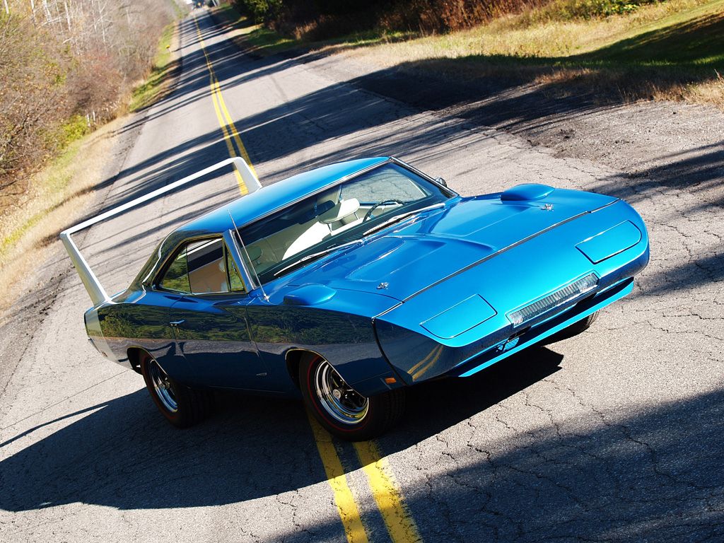 3/4 front view of a glorious bright blue poly 1969 Dodge Charger Daytona in the middle of a tarmac road