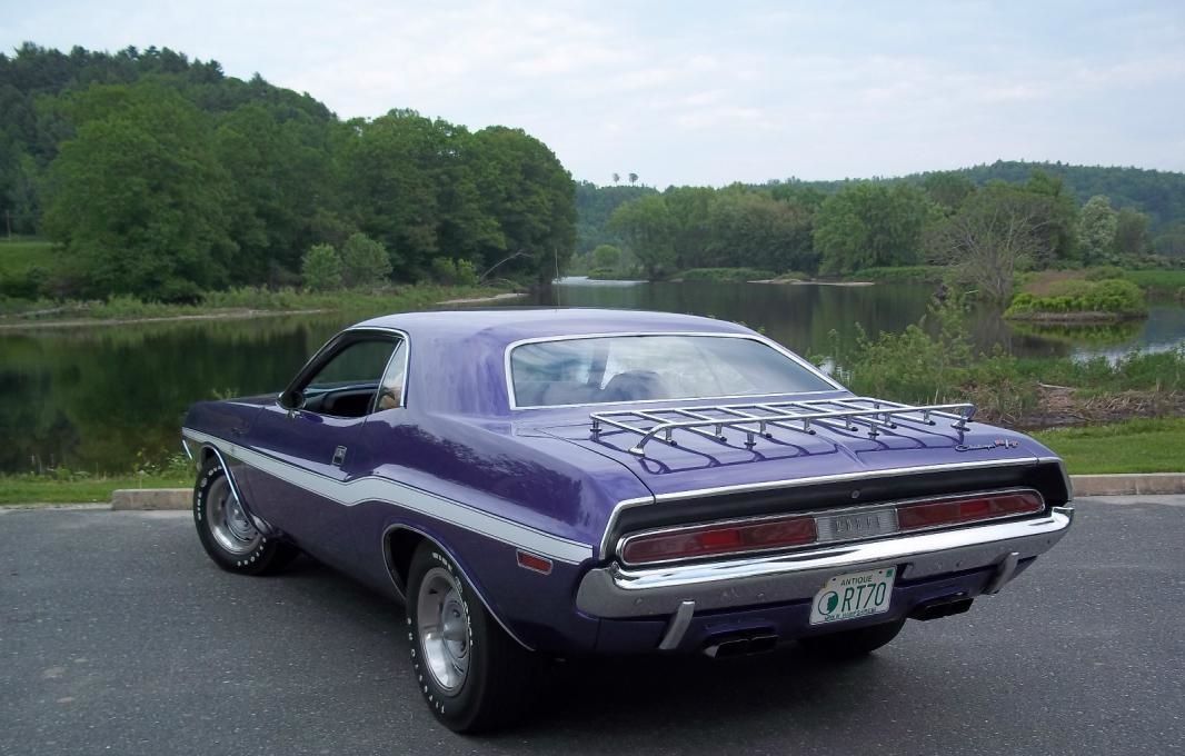 3/4 rear-view of a Plum Crazy Metallic 1970 Dodge Challenger on the tarmac next to a lake
