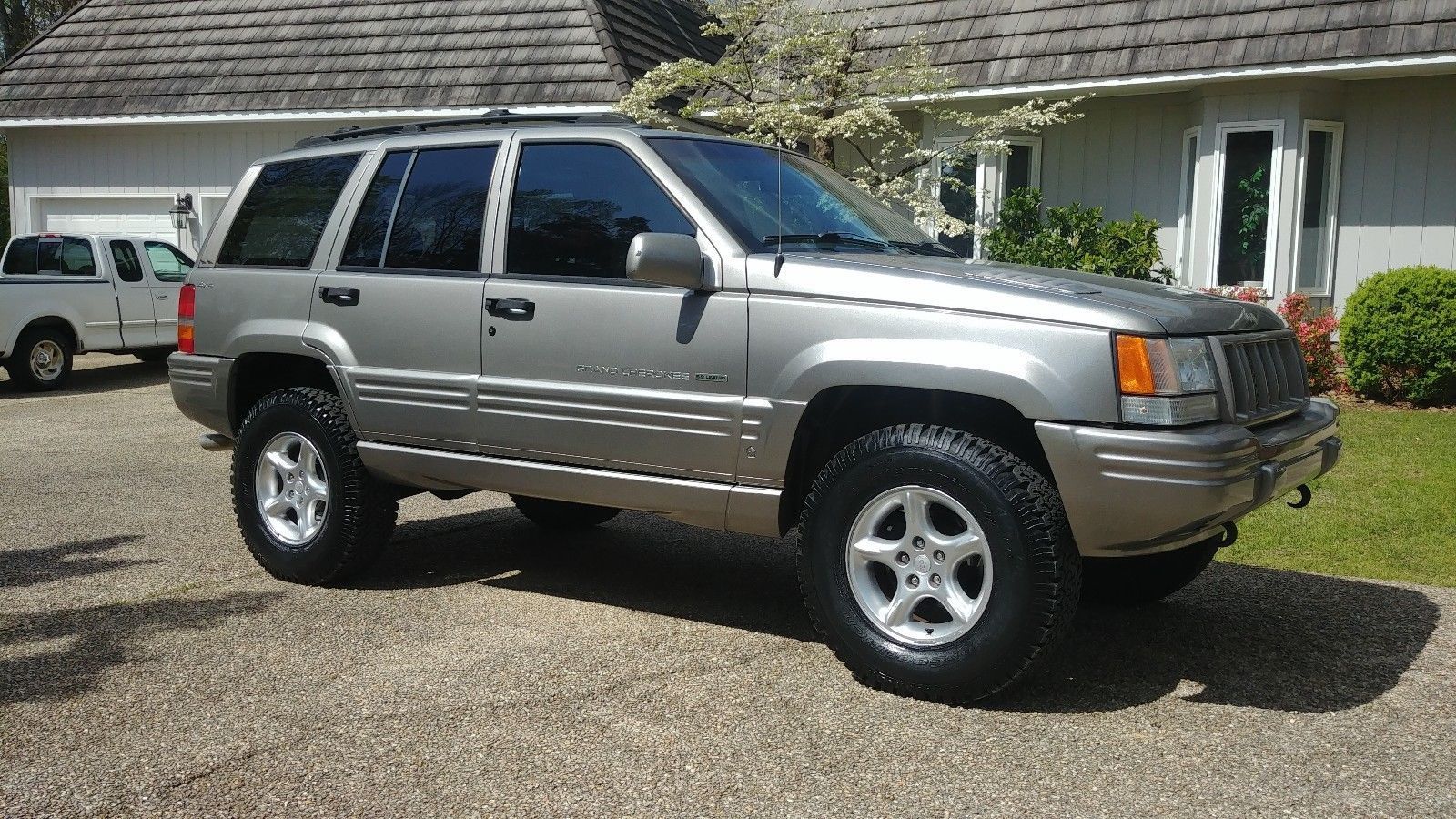 Silver 1998 Grand Cherokee 5.9L parked in front of a house