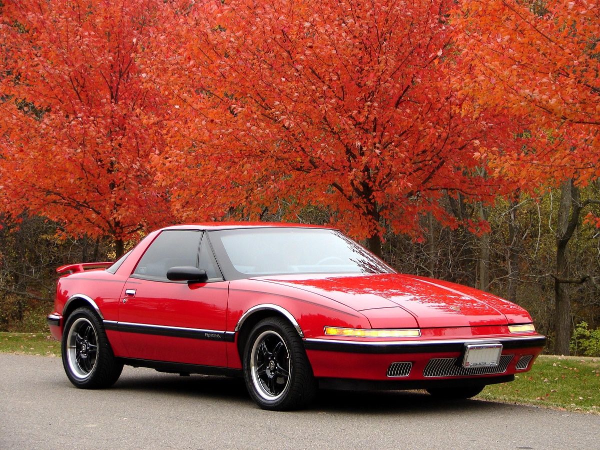 Bright Red Buick Reatta on the side of a road on an autumn day