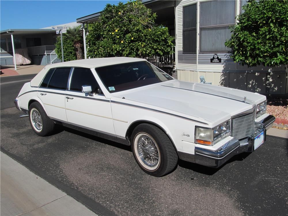 White second-gen Cadillac Seville on the driveway in front of a house