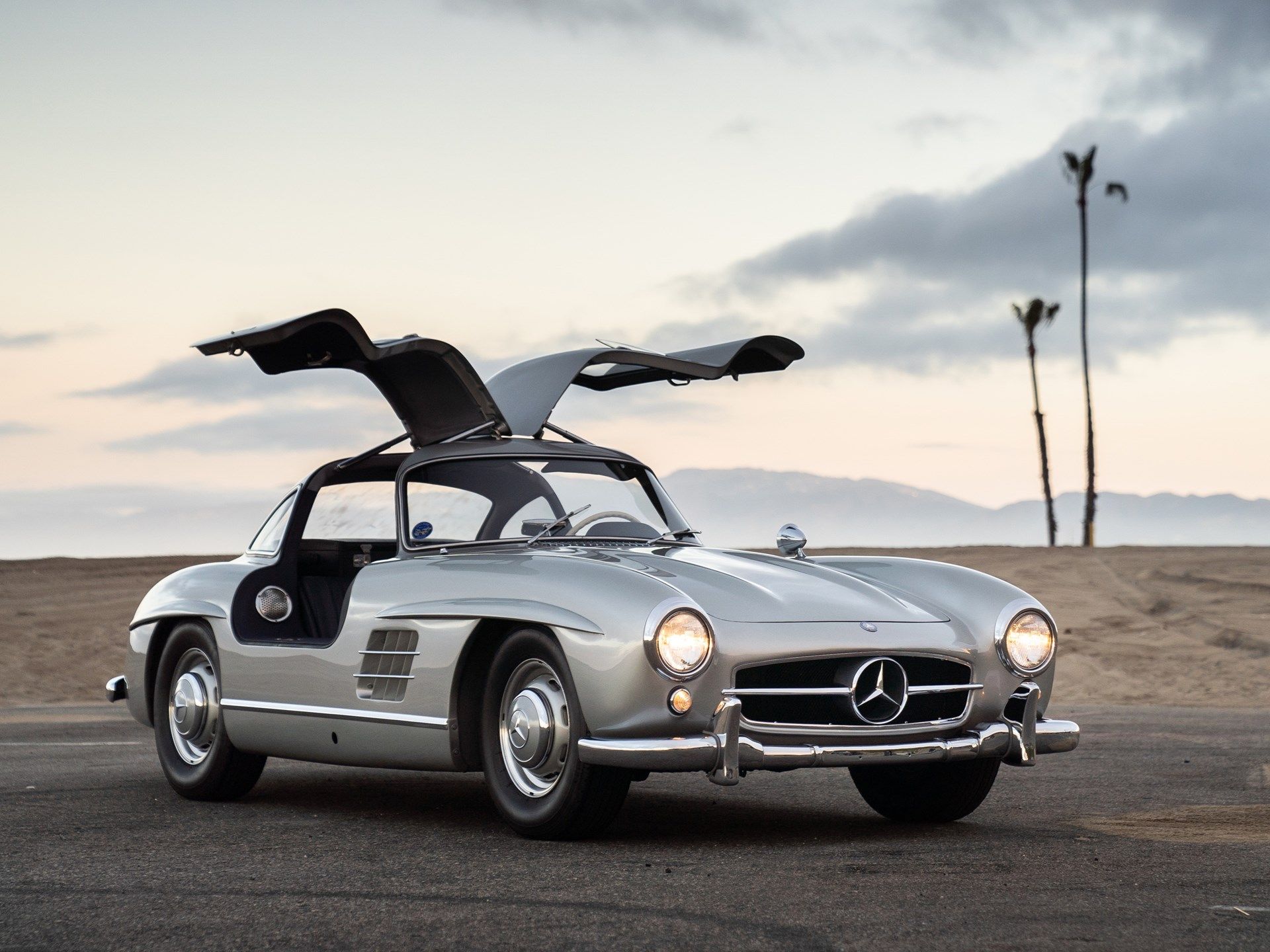 Silver Gray Metallic Mercedes-Benz 300SL Gullwing showing off with its headlights on