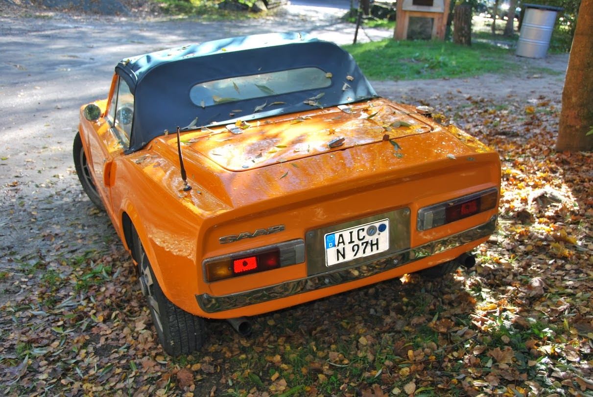 Orange Saab Sonett III parked on the autumn leaves on the side of a residential road