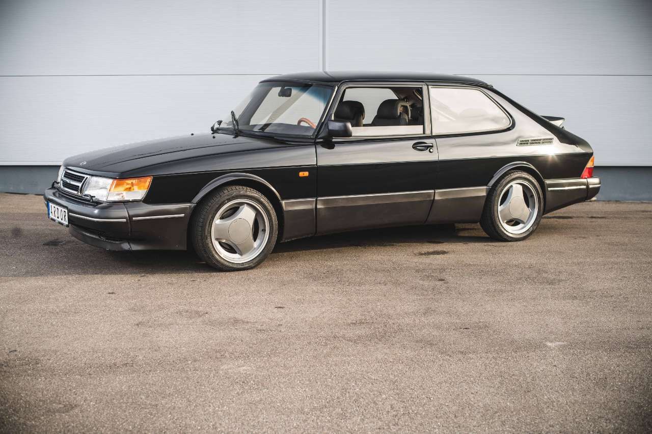 Jet Black Saab 900 Turbo in front of white wall