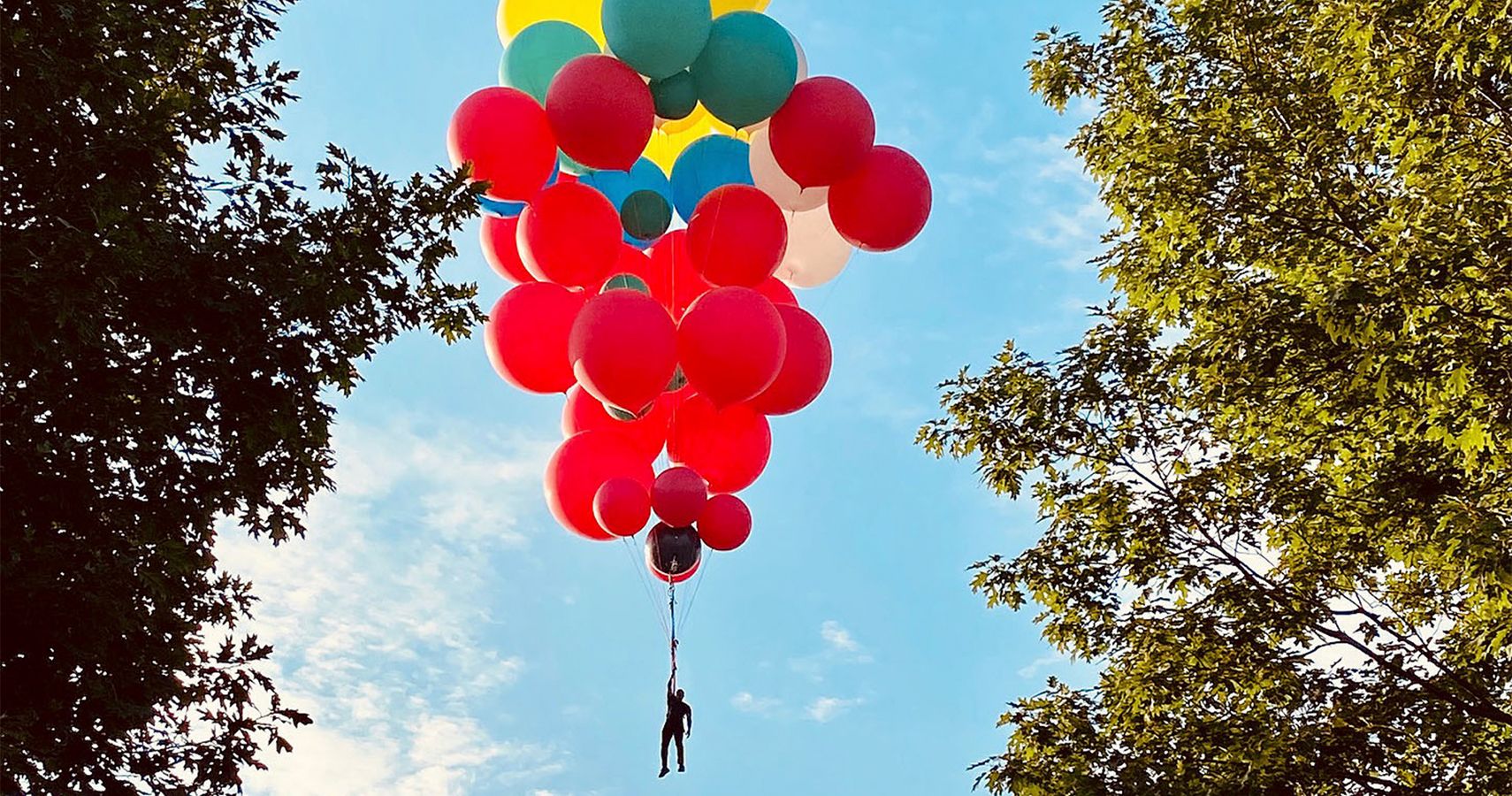 Stunt artist David Blaine hanging from helium balloons
