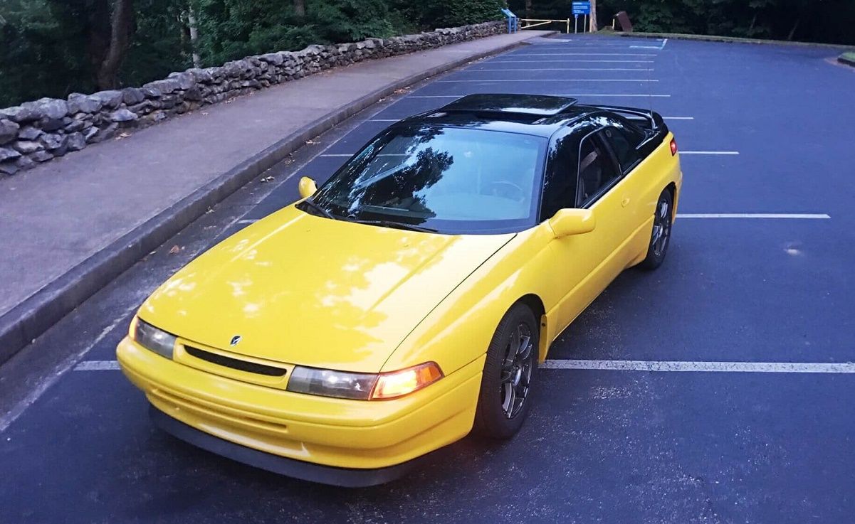 Black-top electric yellow Subaru SVX parked in a parking lot