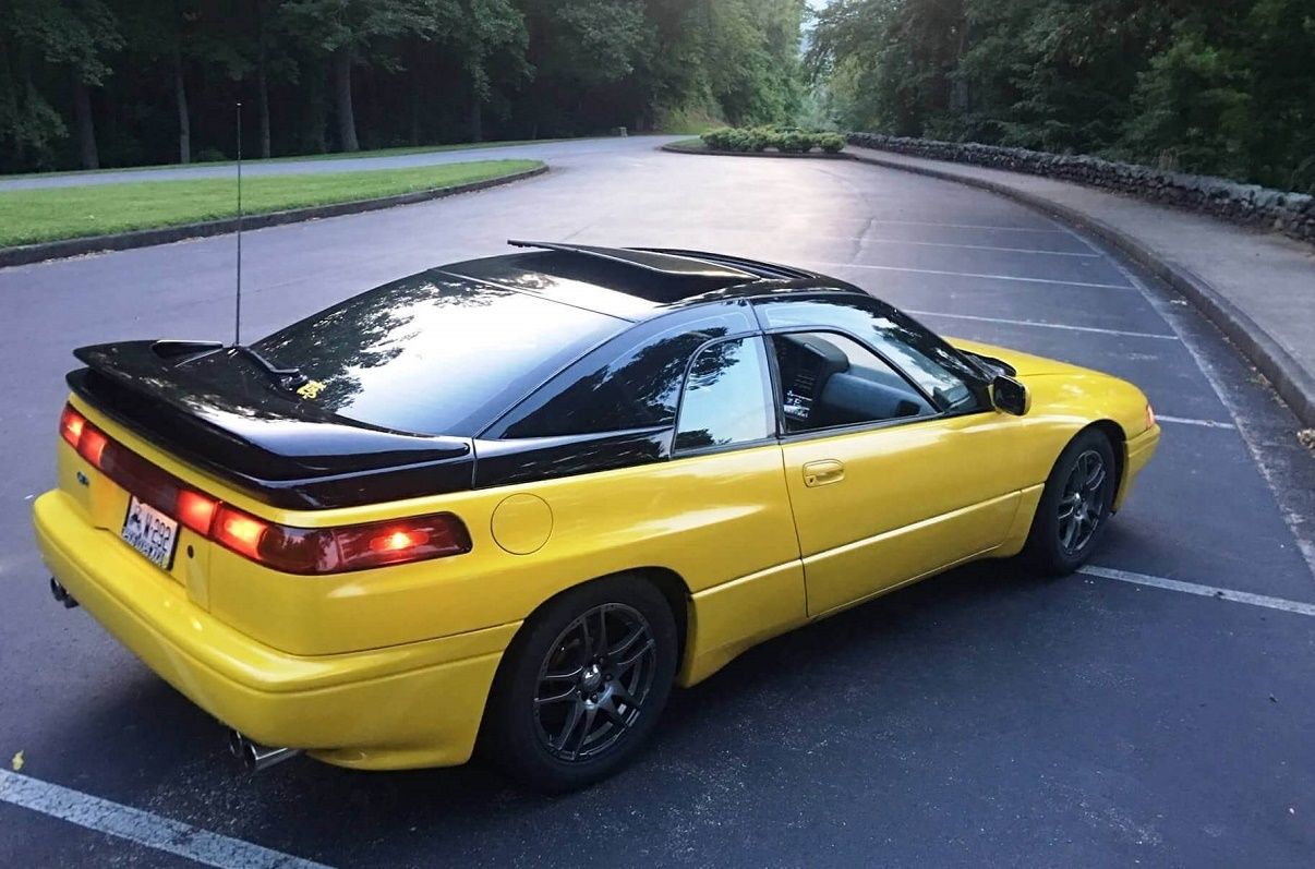 Black-top electric yellow Subaru SVX parked in a parking lot