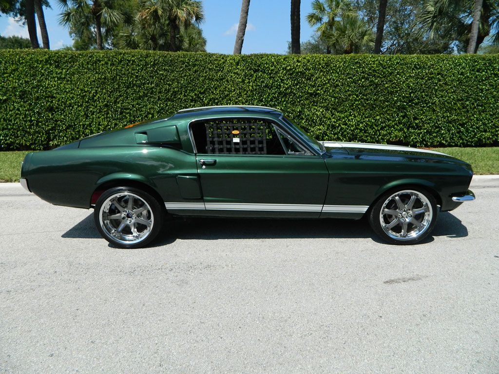 side view of green Mustang in front of green hedge