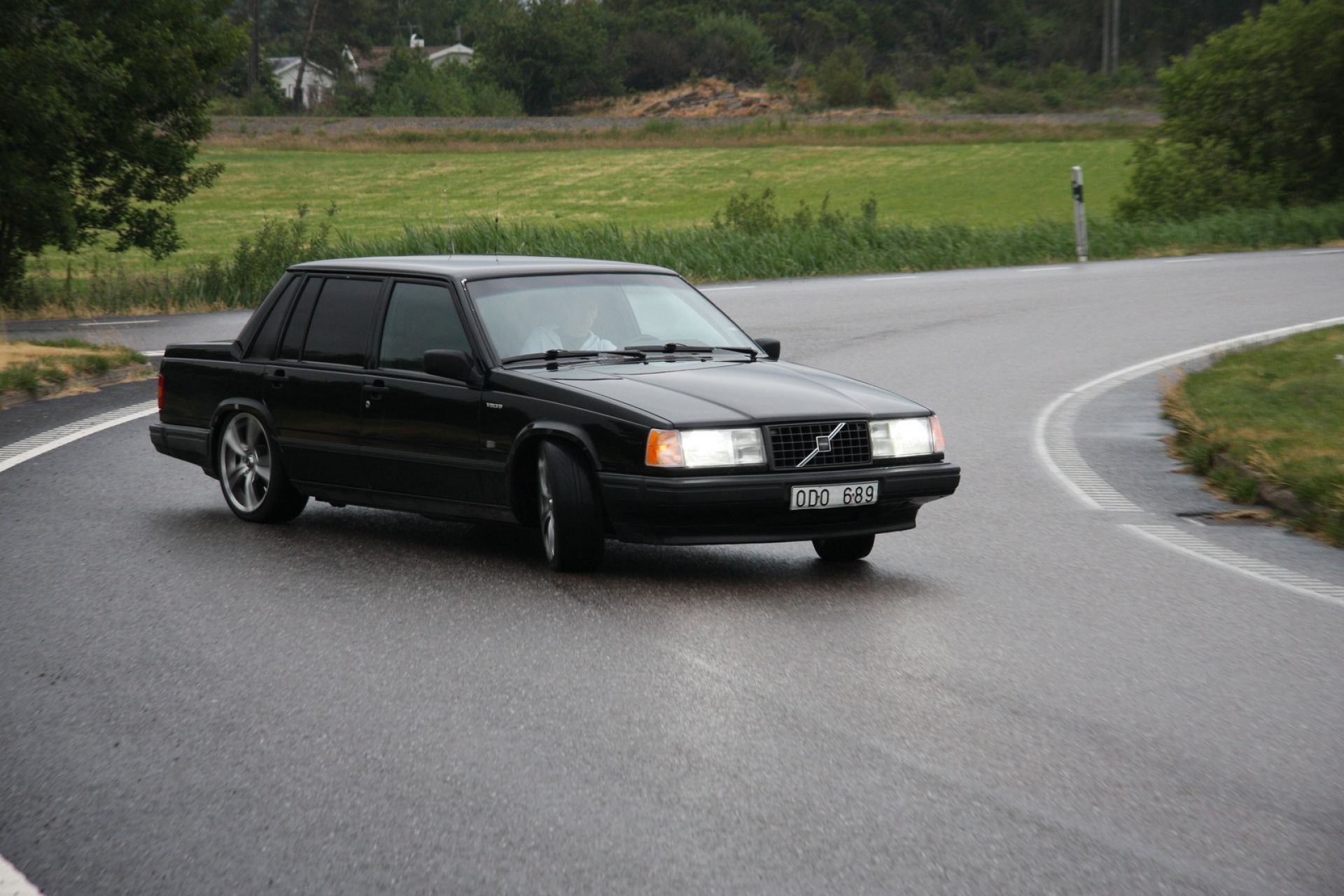 Black Volvo 740 Turbo while drifting on the wet road