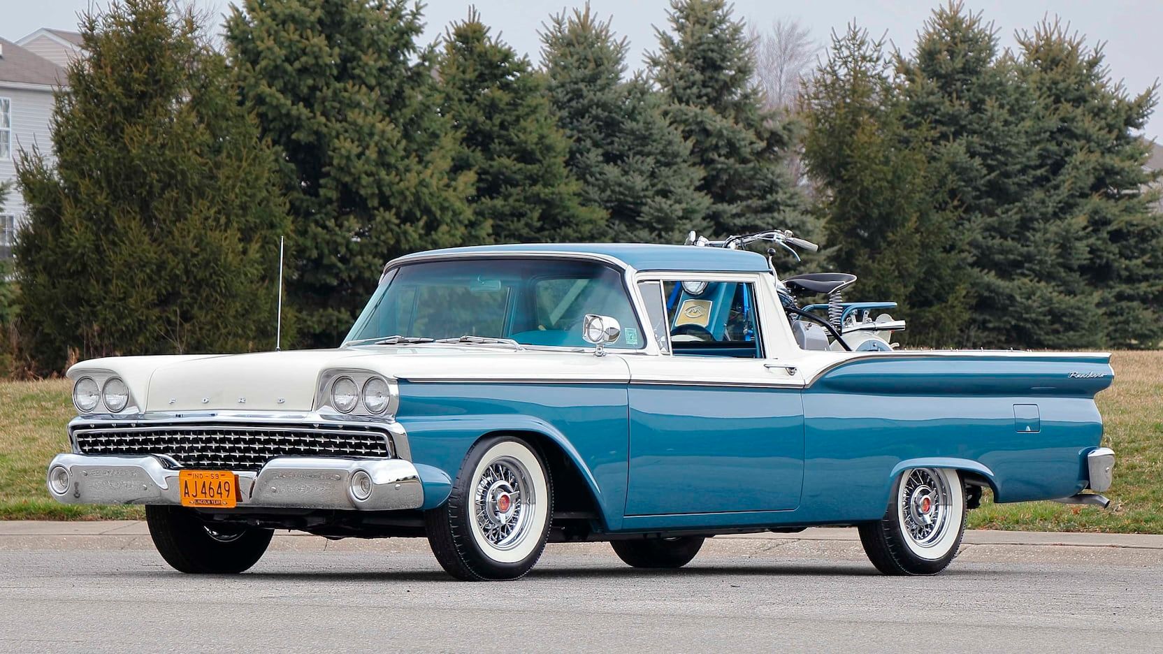 Blue and White 1958 Ford Ranchero carrying a Cushman Eagle bike parked on the tarmac