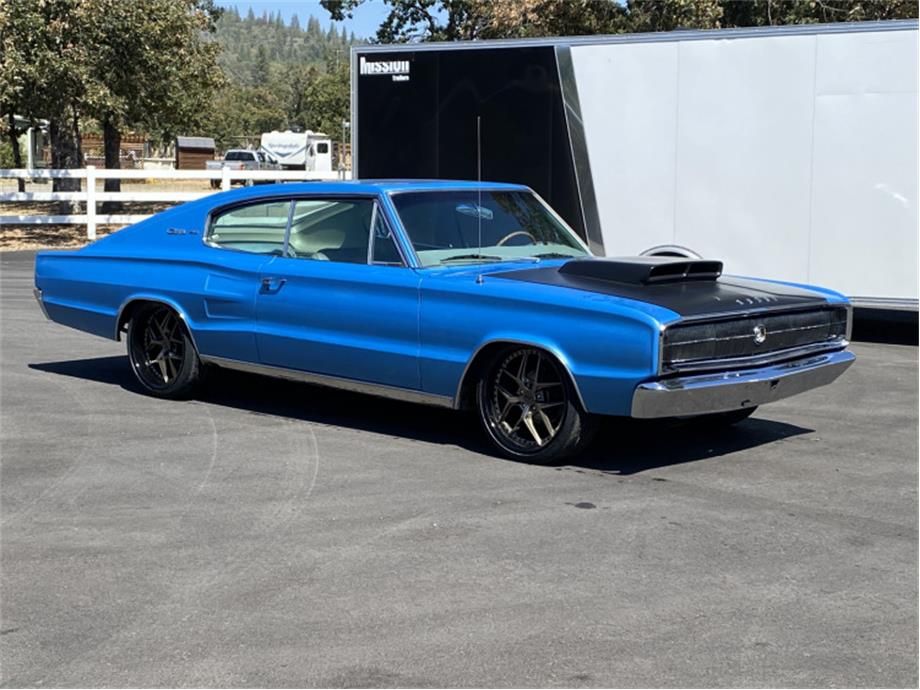 A blue 1966 Dodge Charger stands on a road.