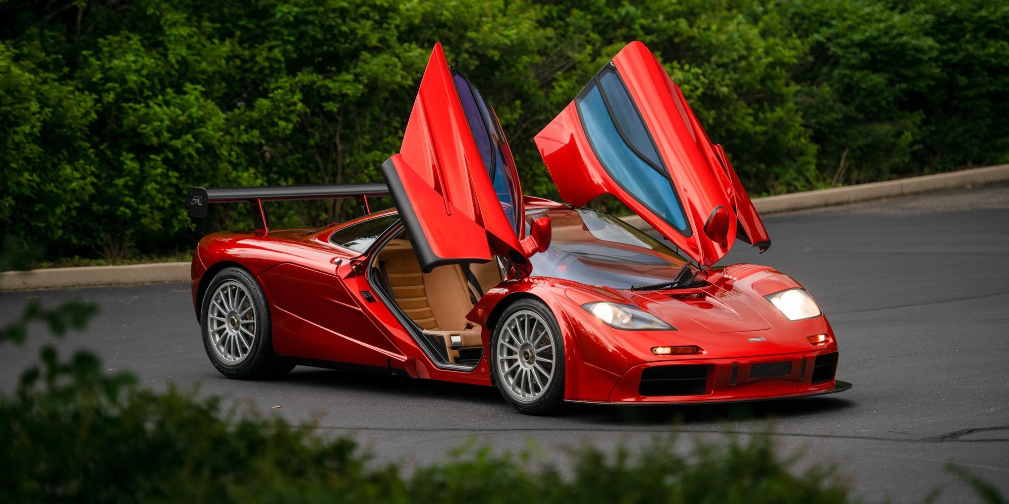 A red 1998 McLaren F1 with its doors pulled up